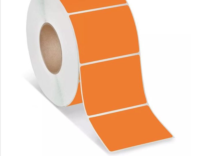 Roll of orange adhesive labels on white backing material