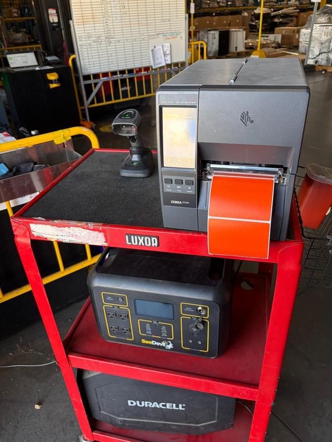 Zebra thermal printer on red LUXOR cart in warehouse