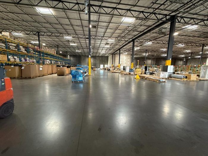 Warehouse interior with concrete floor, storage racks, and inventory boxes