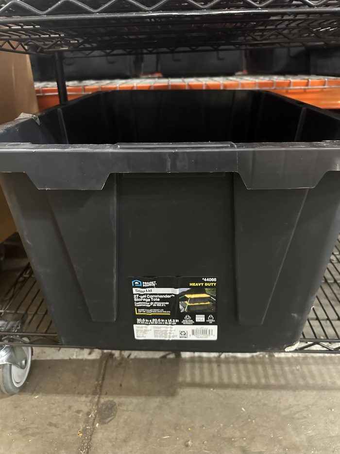 Heavy duty storage tote with lid on warehouse shelving unit