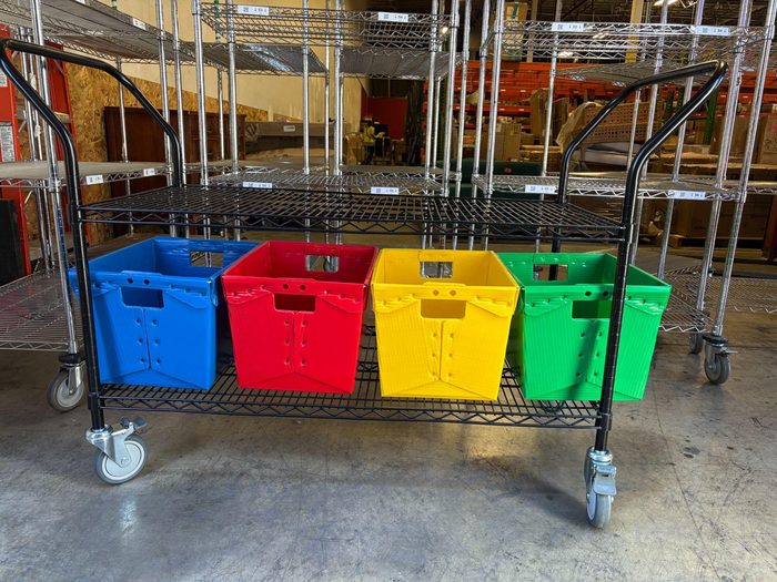 Colored plastic storage totes organized on mobile wire shelving unit