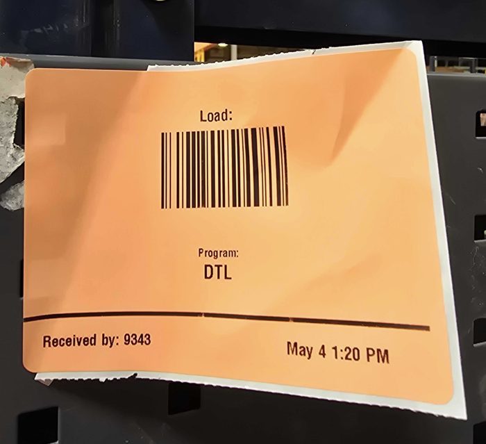 Orange warehouse receipt label with barcode and program designation DTL
