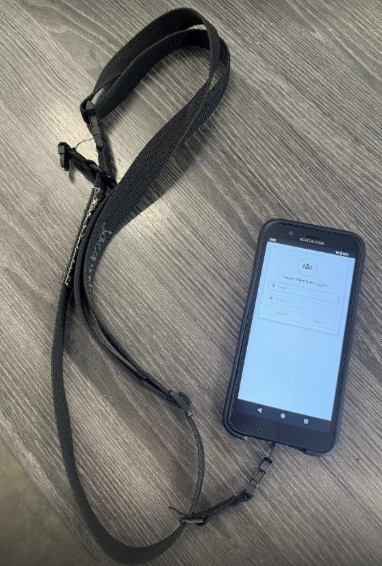 Phone with lanyard displaying Team Member Login screen