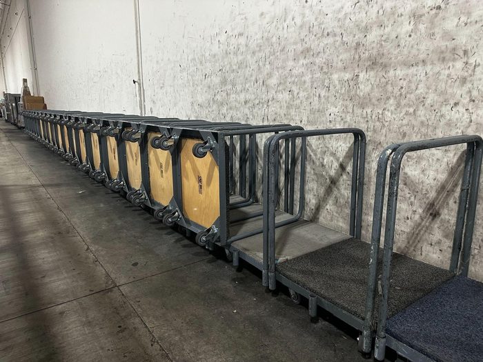 Row of yellow and black equipment totes lined against concrete wall