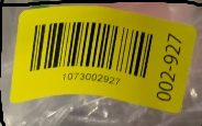 Yellow barcode label on packaged item in warehouse inventory