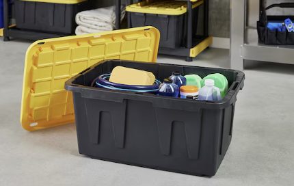 Storage totes with yellow lid and black containers holding supplies