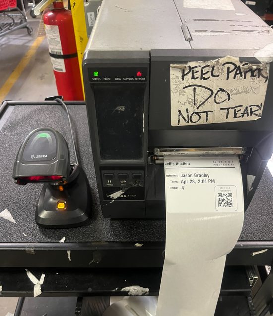Auction warehouse equipment with peel-off label warning sign displayed