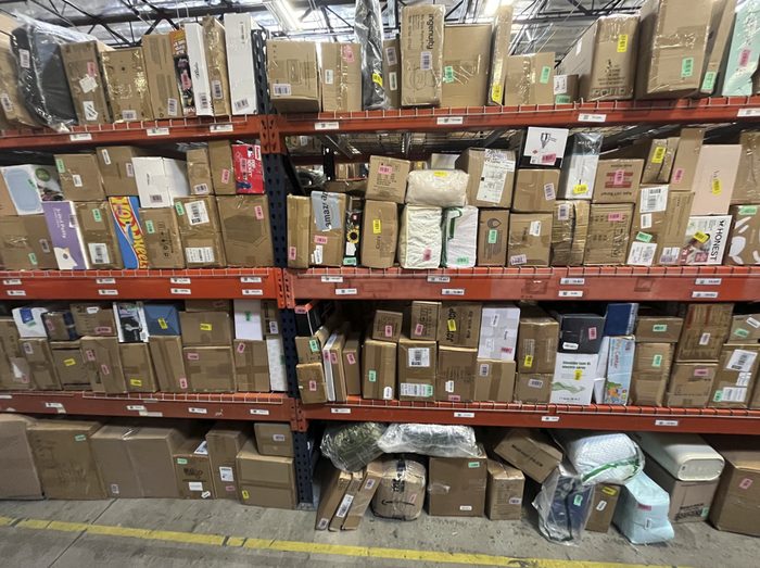 Warehouse shelving units stocked with cardboard boxes and packages