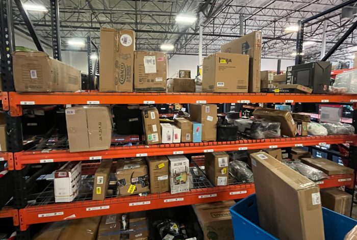 Orange metal shelving units stocked with cardboard boxes and equipment