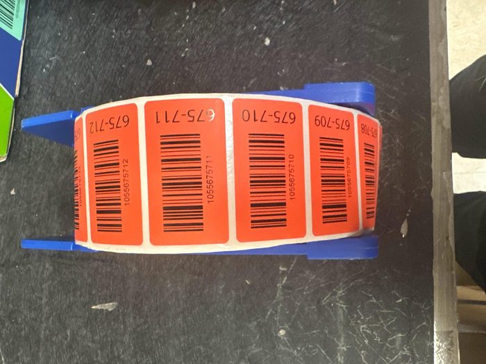 Orange inventory labels with barcodes attached to blue straps