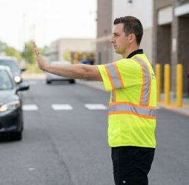 Safety vest worker directing traffic in warehouse parking area