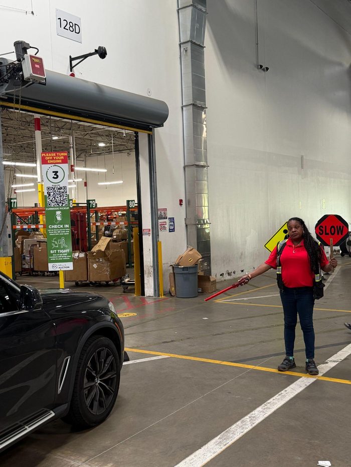 Warehouse employee holding SLOW sign at loading dock bay
